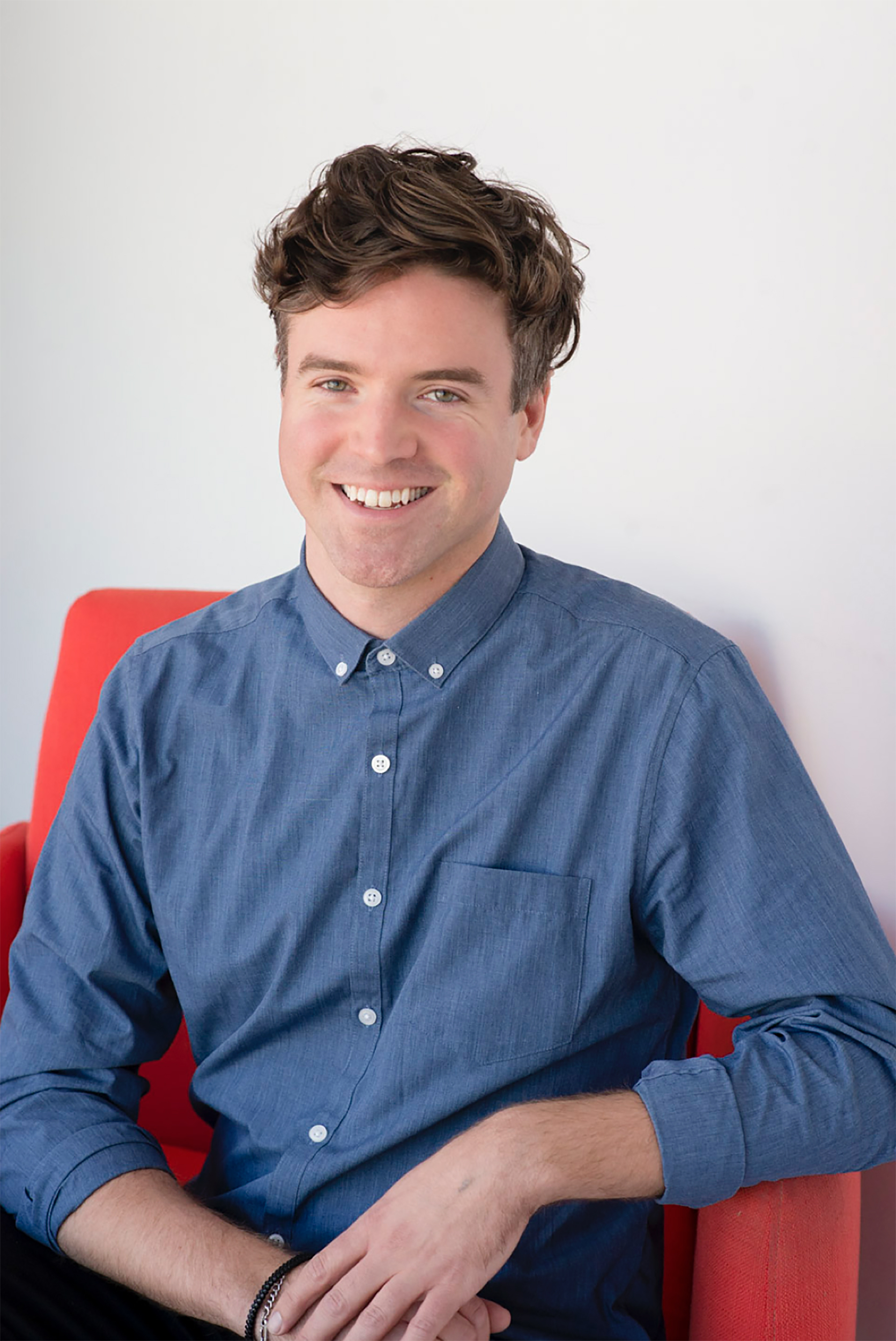 Craig Anderson Headshot seated in red chair